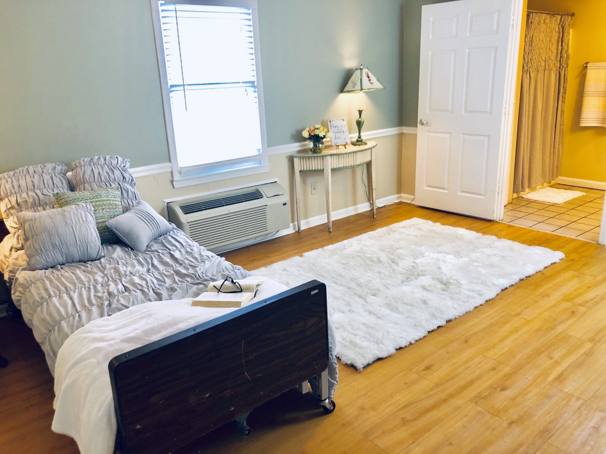 A cozy bedroom with a bed, fluffy rug, and elegant decor.