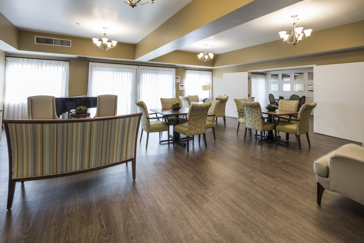 A spacious dining room with elegant furniture and warm lighting.