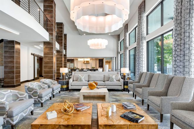 A modern and luxurious living room with elegant furniture and large windows.