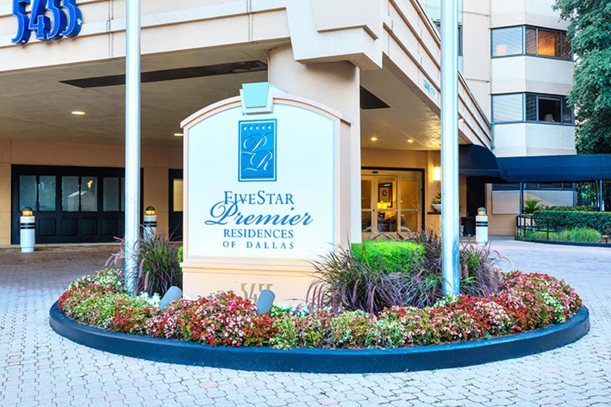Entrance to a hotel with prominent signage and well-maintained landscaping.