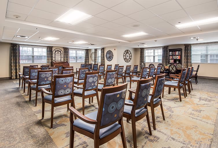 A well-arranged conference room with multiple rows of chairs facing the front.