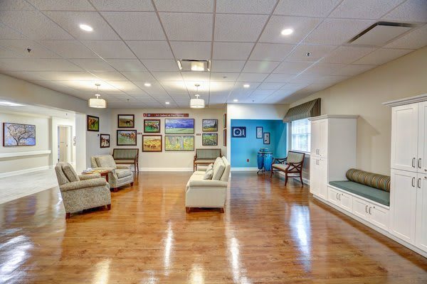 A spacious and elegantly decorated living room featuring comfortable seating and diverse artwork on the walls.