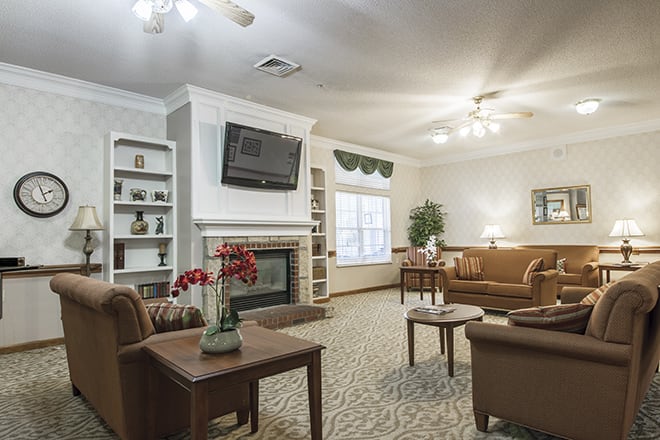 A cozy living room featuring comfortable sofas, a fireplace, and a wall-mounted television.