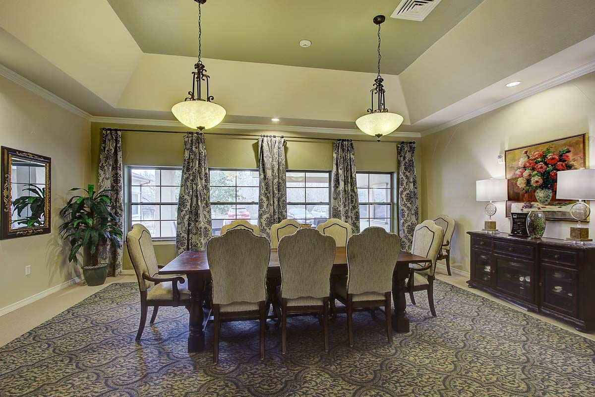 Elegant dining room with a large table and chandeliers.