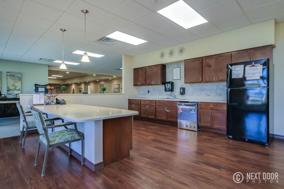 A spacious kitchen with wooden cabinets, modern appliances, and a large countertop island.