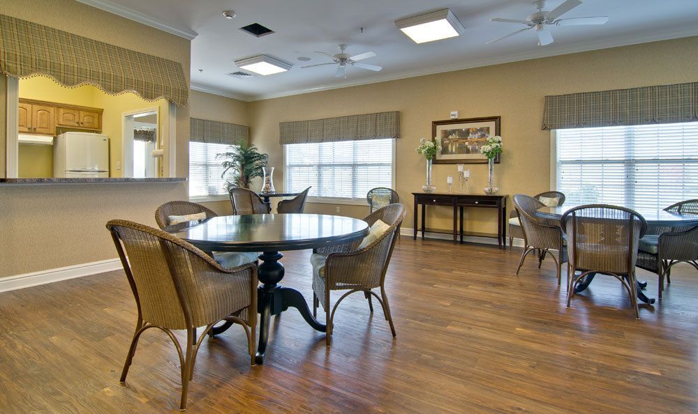 A bright and inviting dining area with a round table, chairs, and wooden flooring.