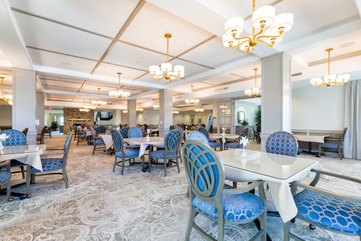 A stylish dining room with blue chairs and elegant chandeliers.