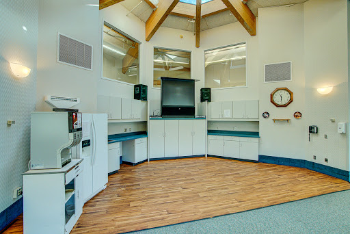 A modern interior space featuring wooden beams, a kitchenette area, and an open layout.
