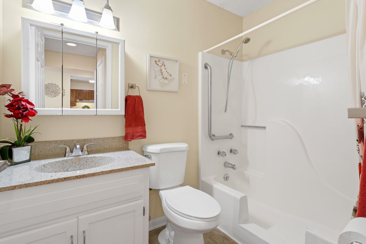 A clean and modern bathroom with a white shower, toilet, and sink.