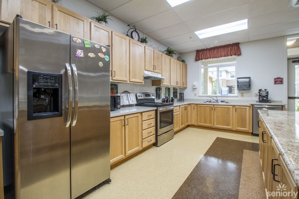 A spacious modern kitchen with wooden cabinets and stainless steel appliances.