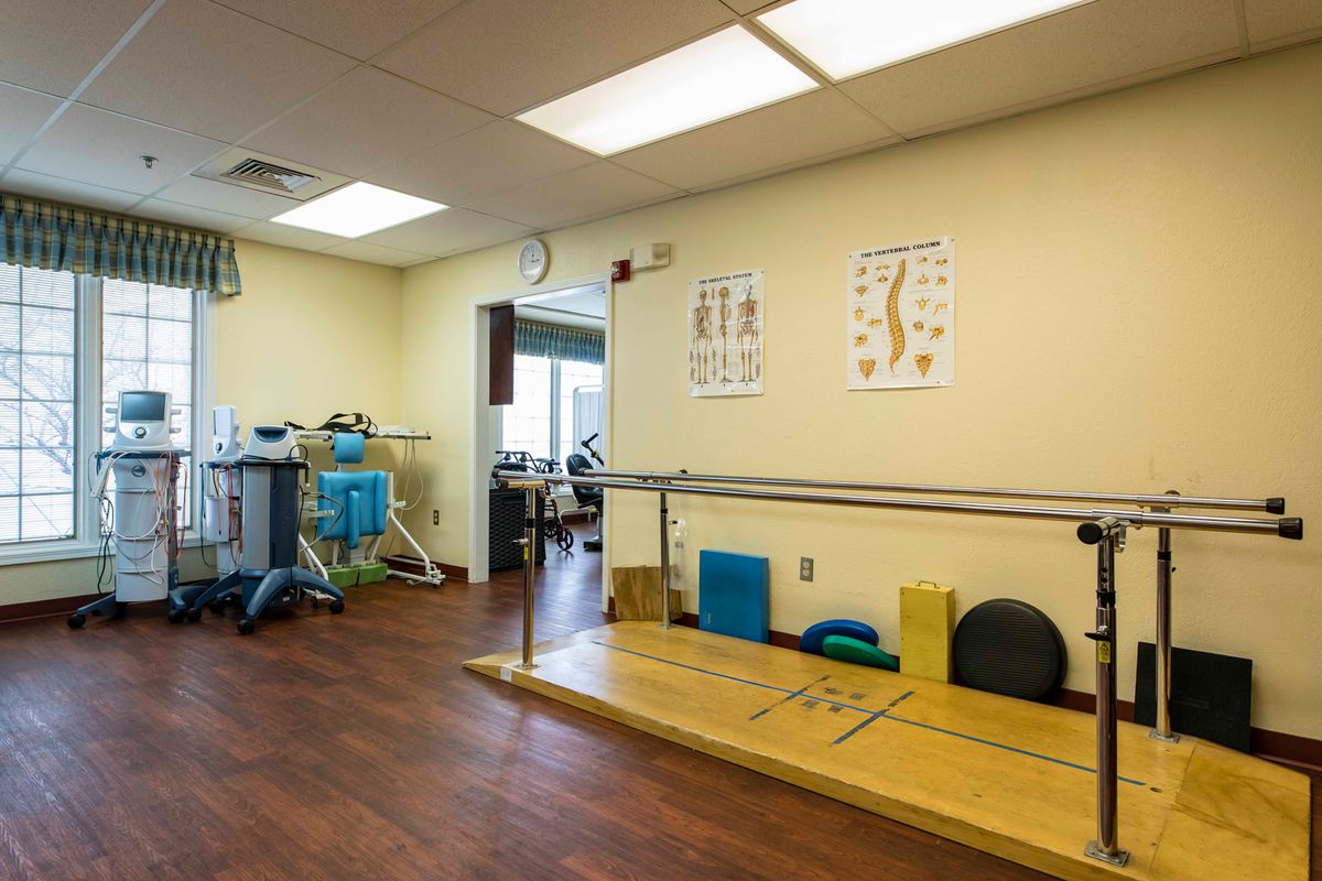 A physical therapy clinic equipped with parallel bars and exercise equipment.