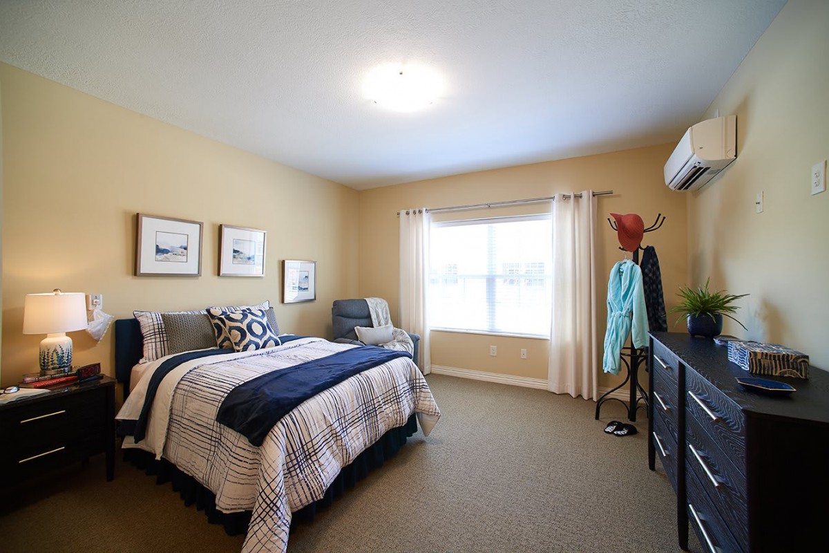 A cozy bedroom with a neatly made bed, soft lighting, and tasteful decor.