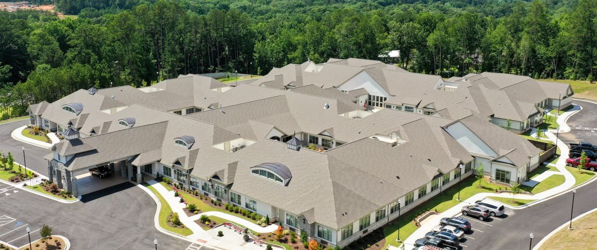 Aerial view of a large building complex surrounded by greenery.