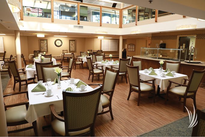 A well-lit restaurant dining area with neatly arranged tables and chairs.