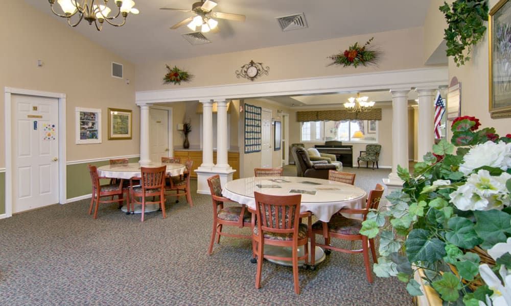 A cozy dining area with neatly arranged tables and chairs, featuring simple yet elegant decor.