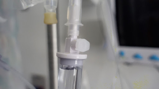 Close-up of an intravenous (IV) connection used for administering medication or fluids in a medical setting.