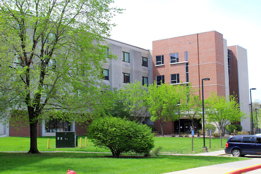 A view of a modern building surrounded by lush greenery.
