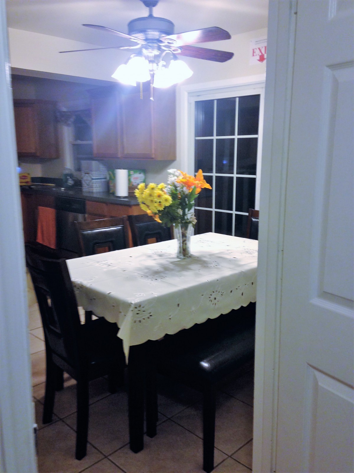 A cozy kitchen with a dining table adorned with a vase of flowers.