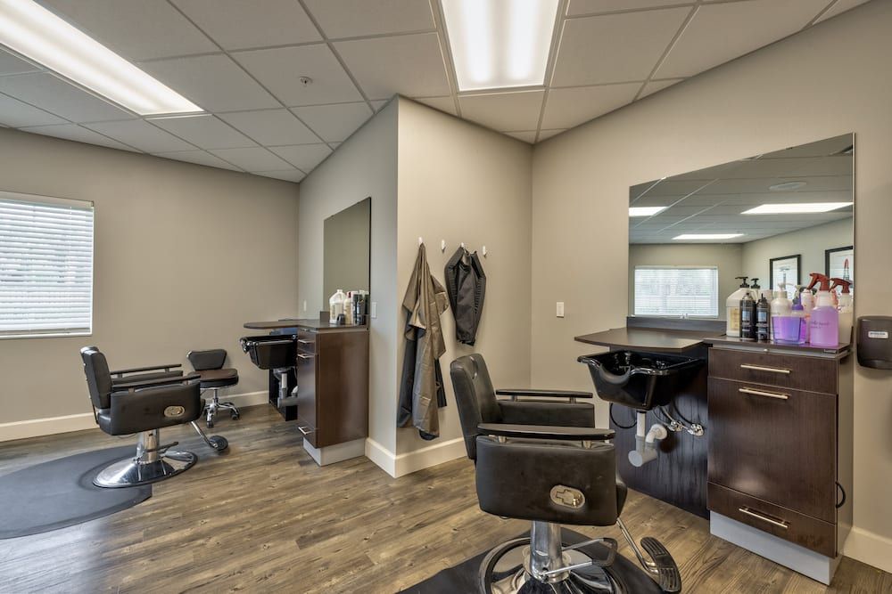 Interior view of a modern barbershop with styling stations and chairs.