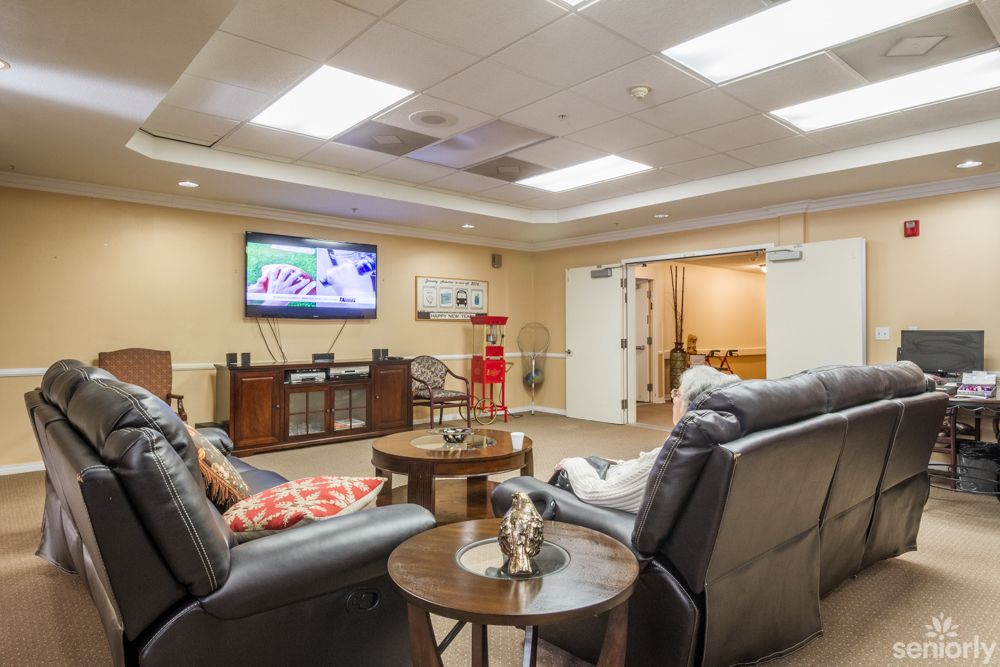 A cozy lounge area featuring recliner chairs and a wall-mounted television.