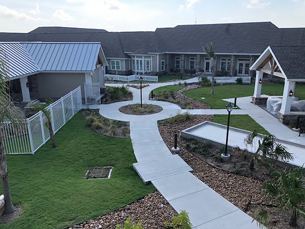 A well-maintained courtyard with multiple pathways and landscaped gardens surrounded by buildings.