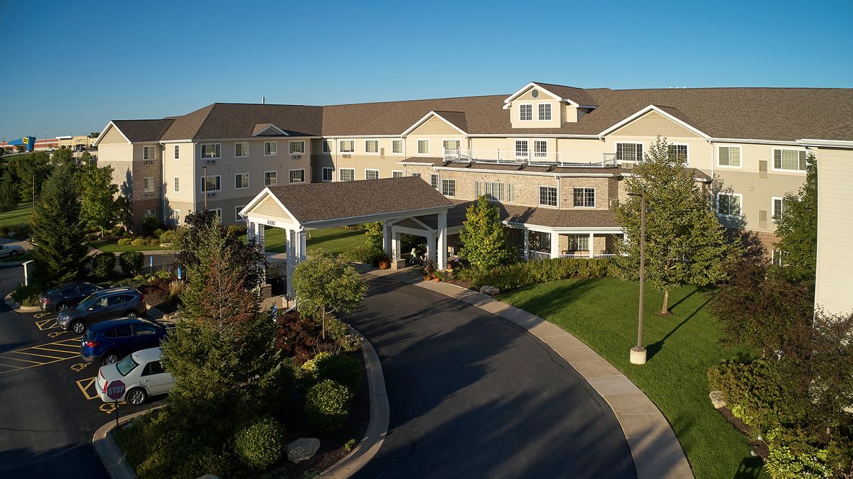 A well-maintained residential building with a landscaped entrance and driveway.