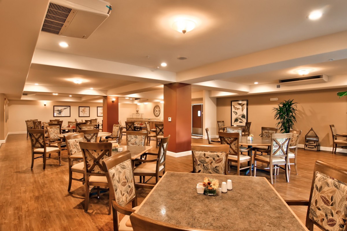 A well-lit indoor dining area with neatly arranged tables and chairs.