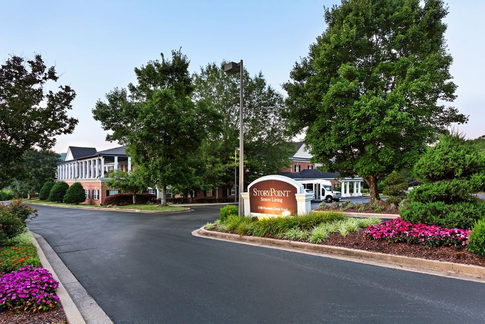 Entrance to a hotel with well-maintained landscaping and clear signage.
