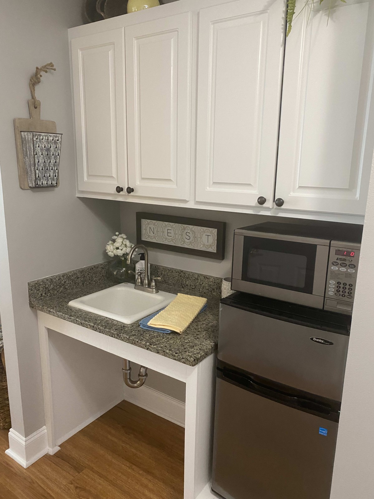 A compact modern kitchen setup with a microwave and sink.