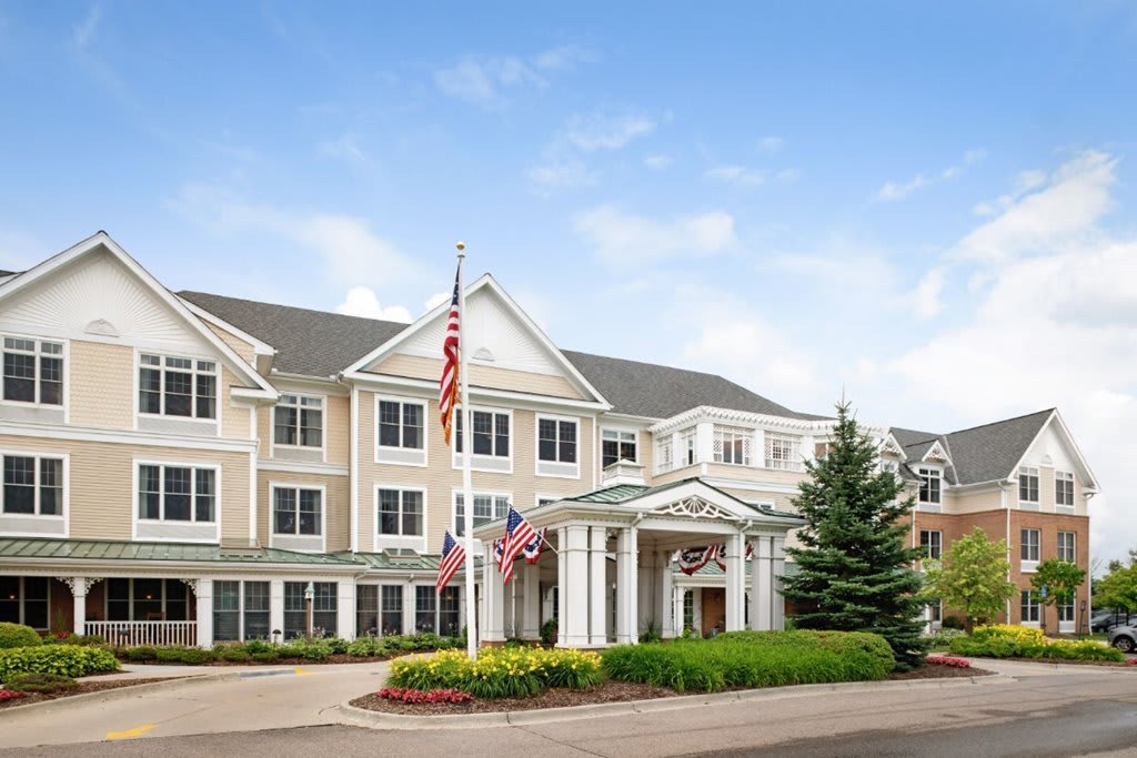 A large residential building with American flags and well-maintained landscaping.