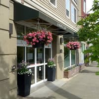 A charming storefront with hanging flower baskets and a well-maintained sidewalk.