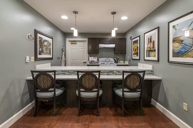 Modern kitchen with a marble countertop, bar stools, and pendant lighting.