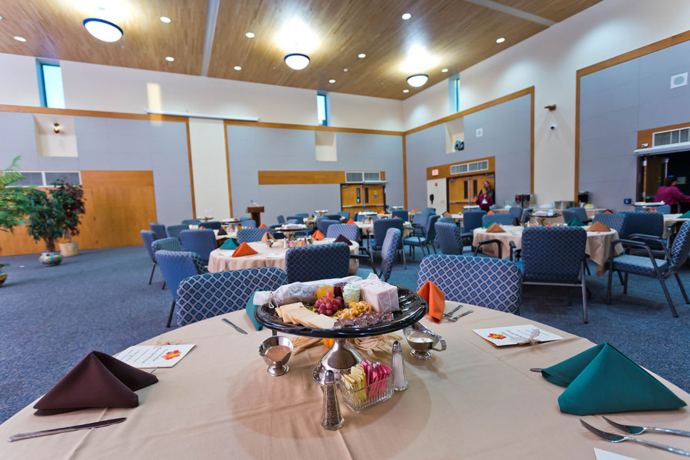 A spacious banquet hall set up with dining tables and chairs, ready for an event.