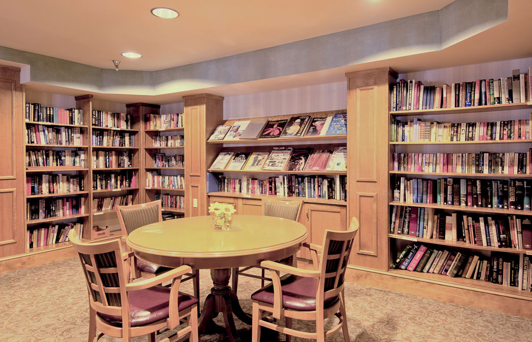 A cozy library reading area with a round table and bookshelves filled with books.