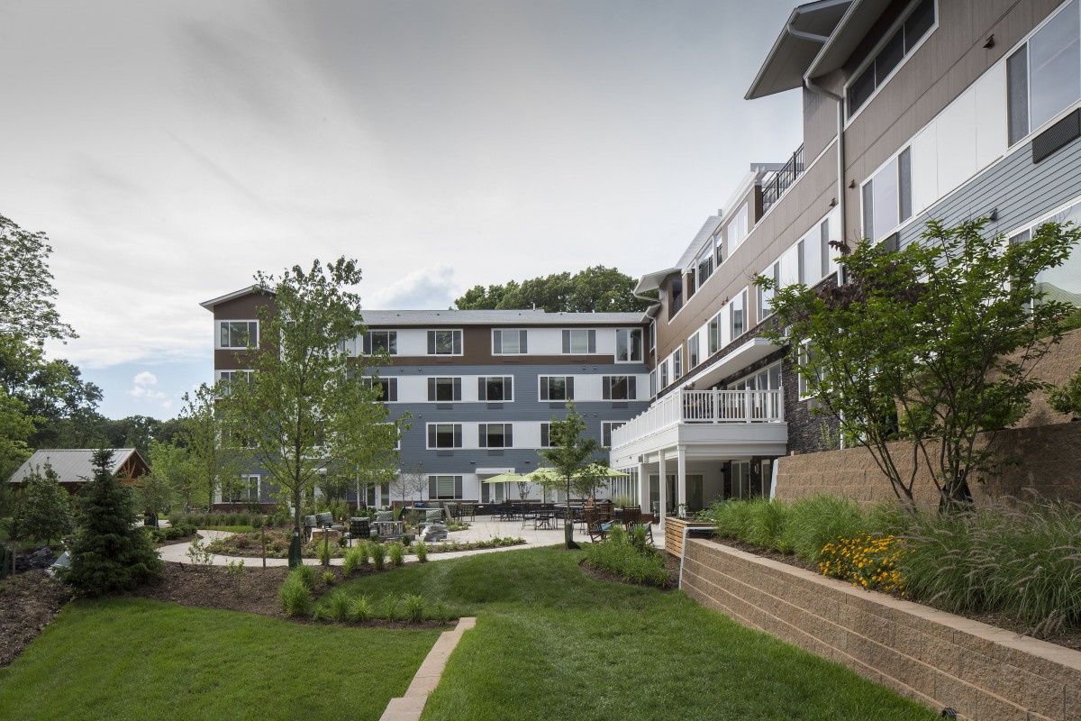 A modern residential building with well-maintained landscaping and a garden pathway.