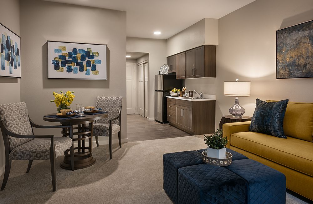 A modern apartment living space featuring a kitchenette, dining area, and stylish furniture.
