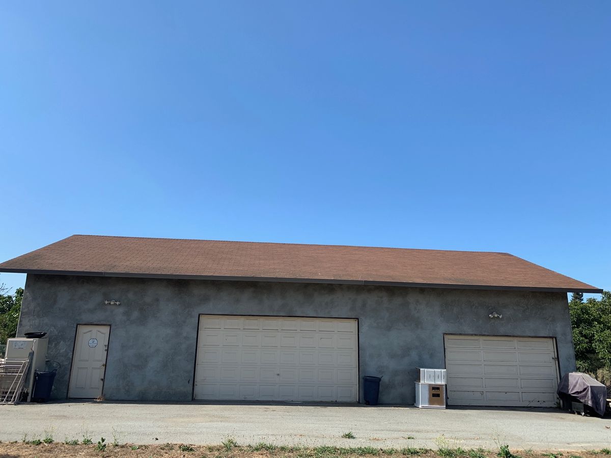 A large building with multiple garage doors under a clear blue sky.