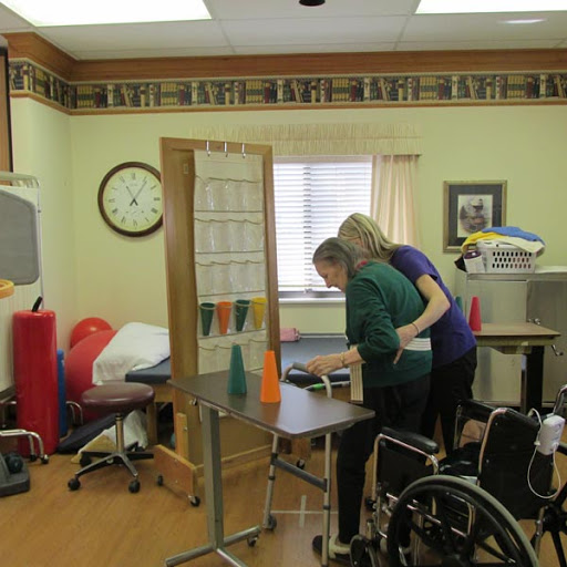 A healthcare professional assists a patient in a rehabilitation setting.