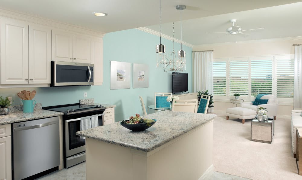 Modern open-concept kitchen and living room with sleek appliances and light decor.
