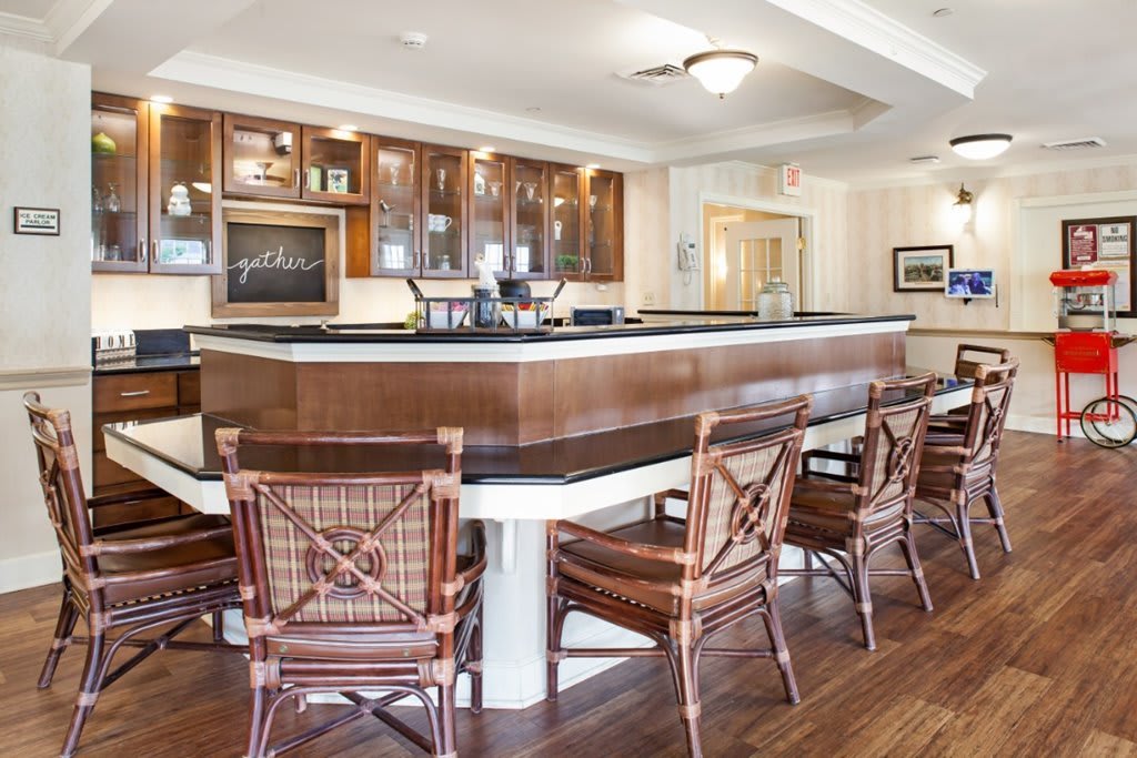 A stylish bar area with wooden chairs and a polished counter.