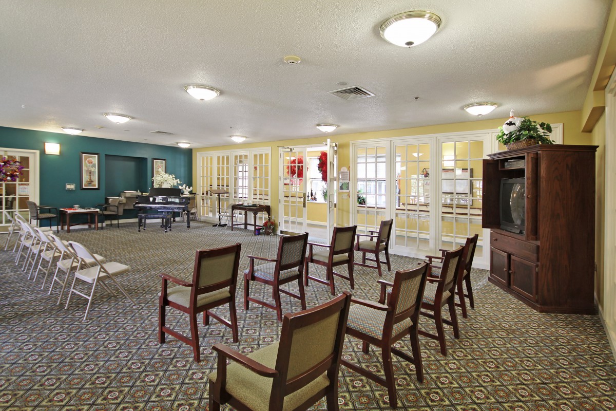 A spacious meeting room with arranged chairs and bright windows.