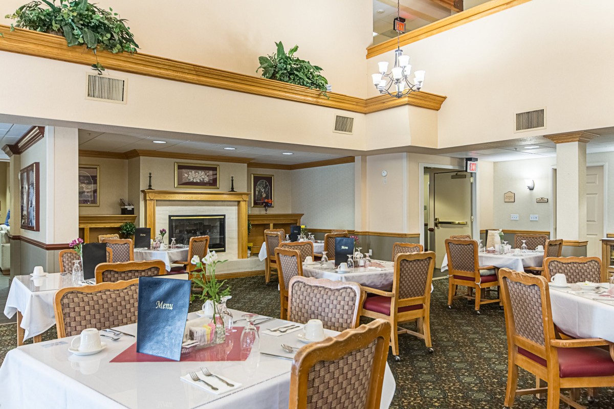 A spacious dining area with neatly arranged tables and a cozy fireplace.