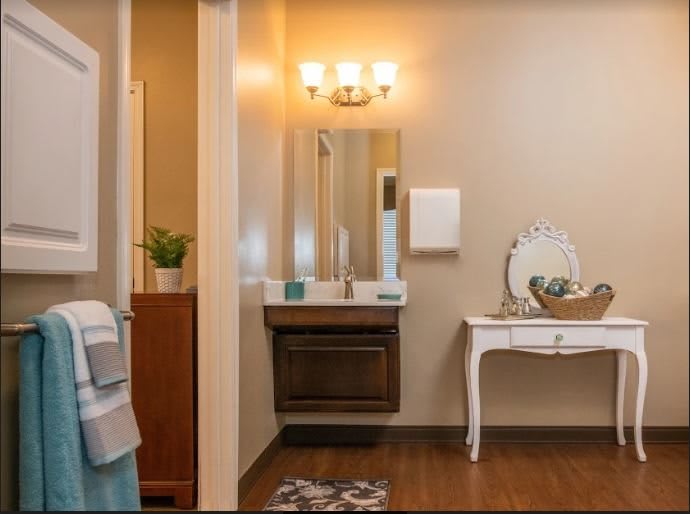 A cozy bathroom with a well-lit vanity area and elegant decor.