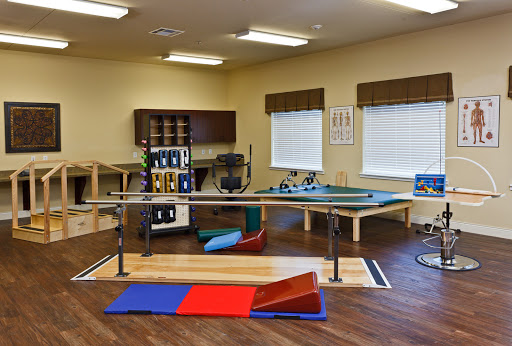 A well-equipped physical therapy room featuring various exercise tools and mats for rehabilitation purposes.
