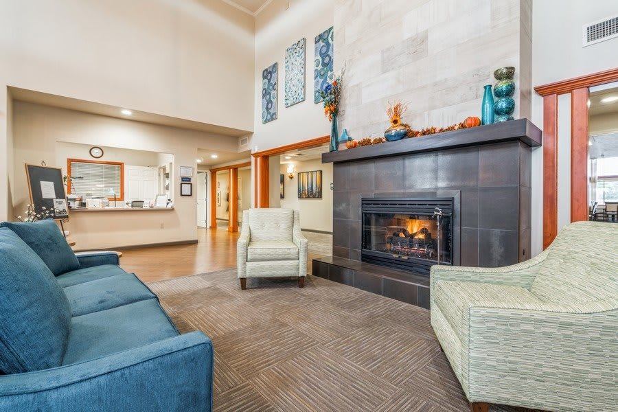 A cozy lobby with comfortable seating and a fireplace.