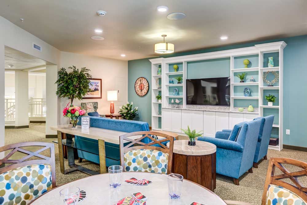 A cozy and modern living room with blue sofas, built-in shelves, and a television.