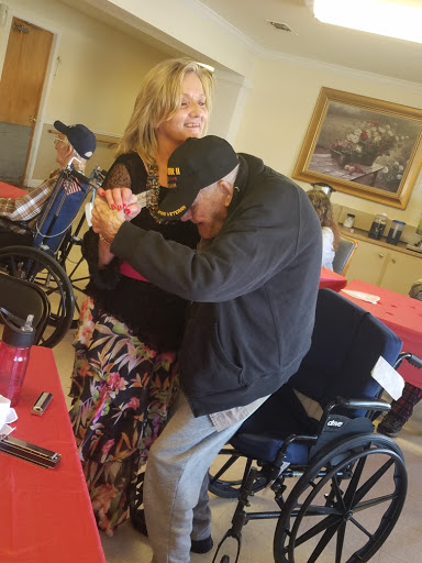 A warm moment of connection between a caregiver and a resident in a care facility.