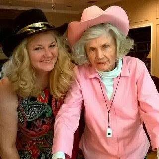 Two women wearing hats, smiling indoors.