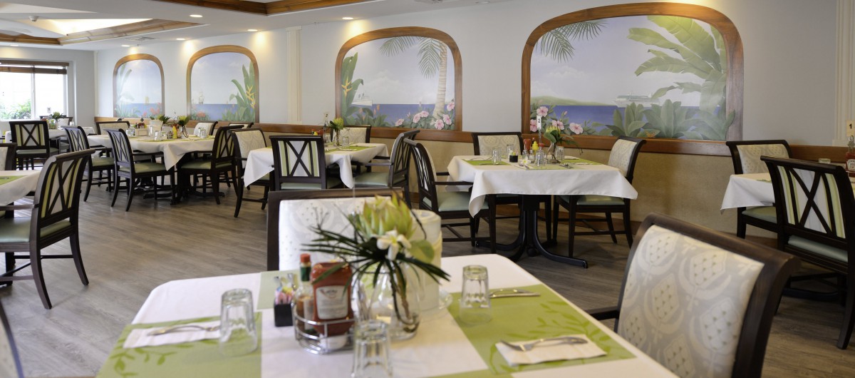 A cozy restaurant dining area with neatly set tables and floral decorations.