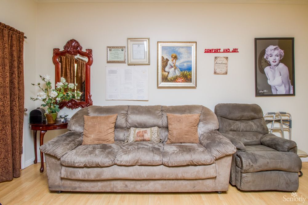A cozy living room with a plush sofa, artwork, and decorative elements on the wall.